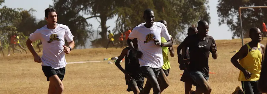 A group of people running in the grass.