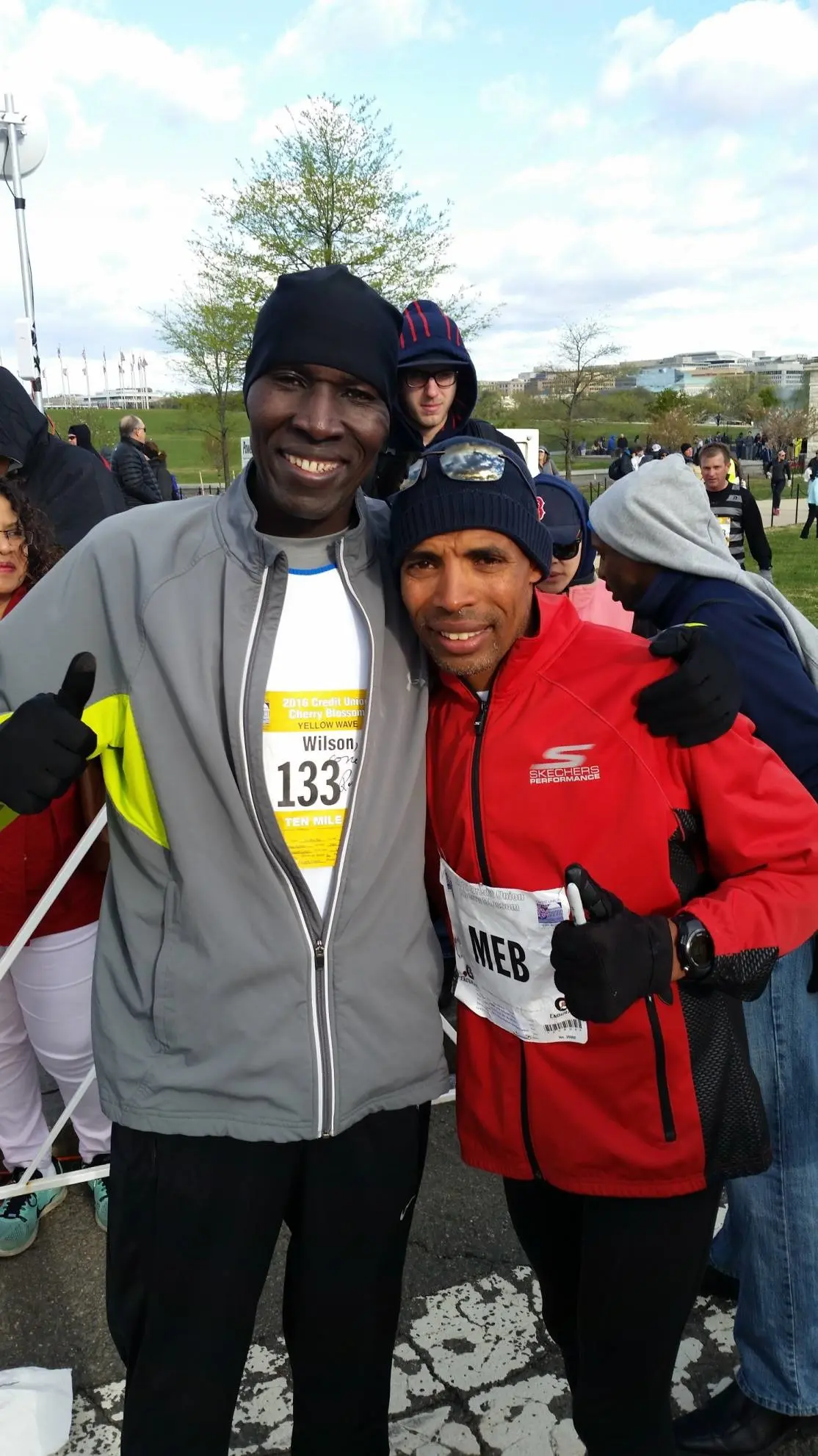 Two men are posing for a picture while wearing winter hats.