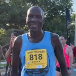 A man is running in the marathon wearing blue