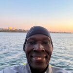 A man in a cap and jacket is smiling for the camera.