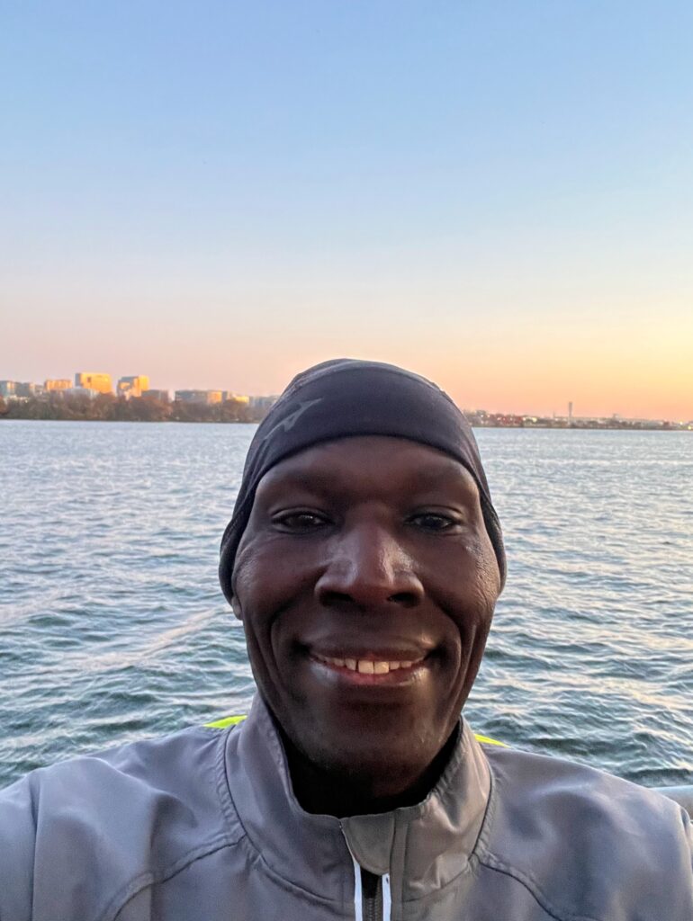 A man in a cap and jacket is smiling for the camera.